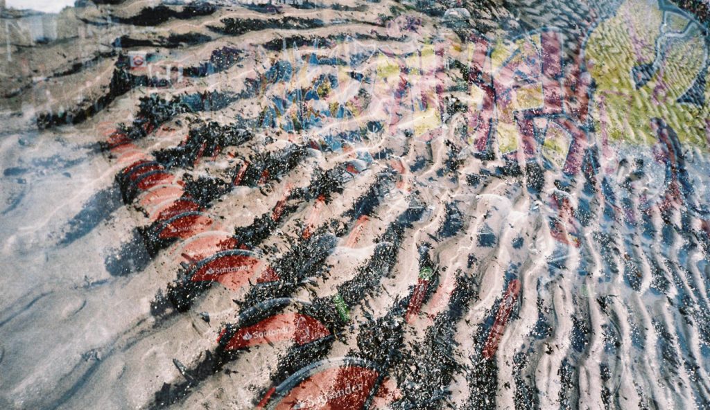 Double exposure photograph of city bikes overlaid with sand ripple textures, urban and nature film swap.
